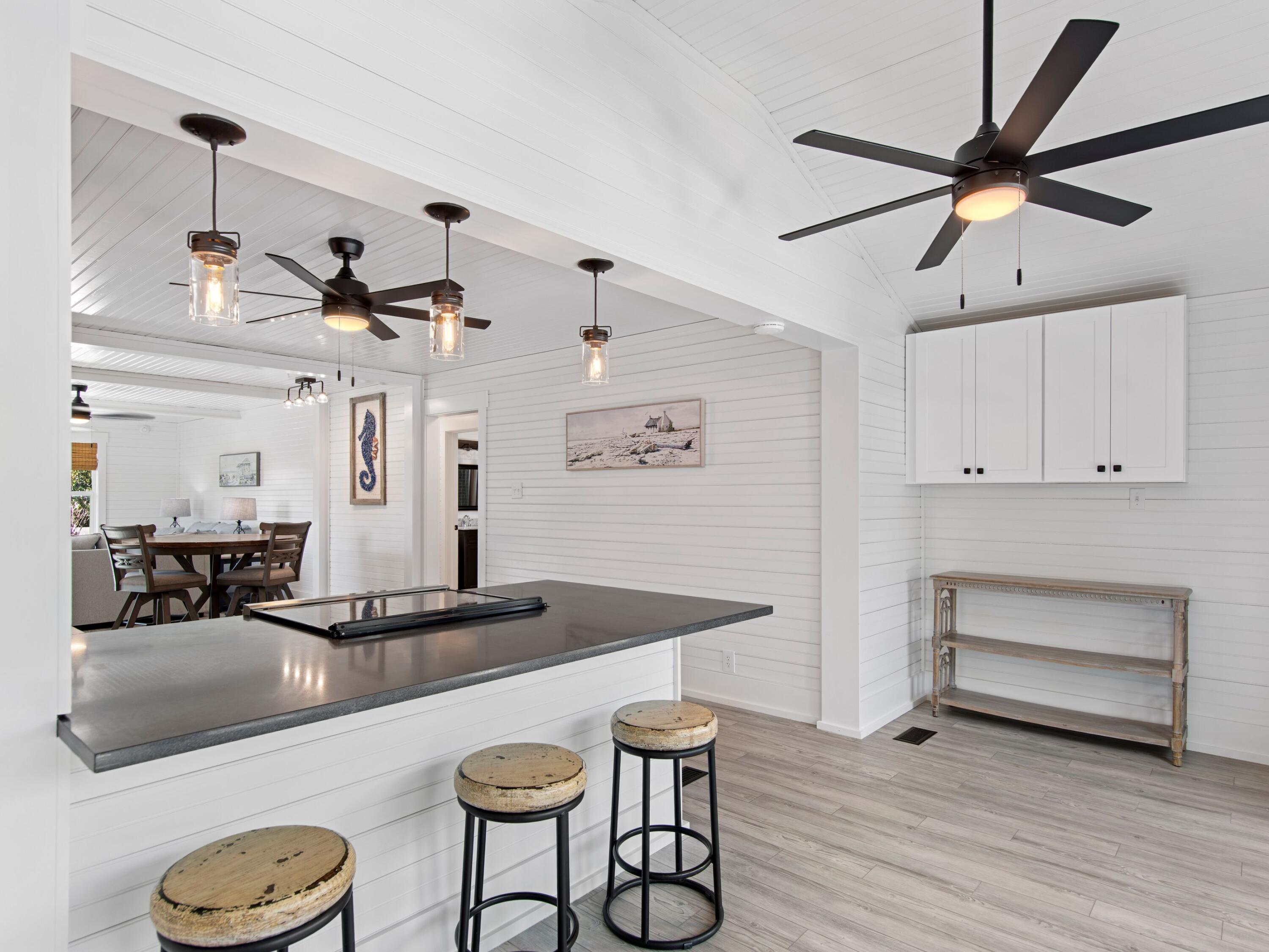 89 Tarpon Street Destin, FL 32541 - Photo 46 of 53 a kitchen with a table chairs refrigerator and wooden floor