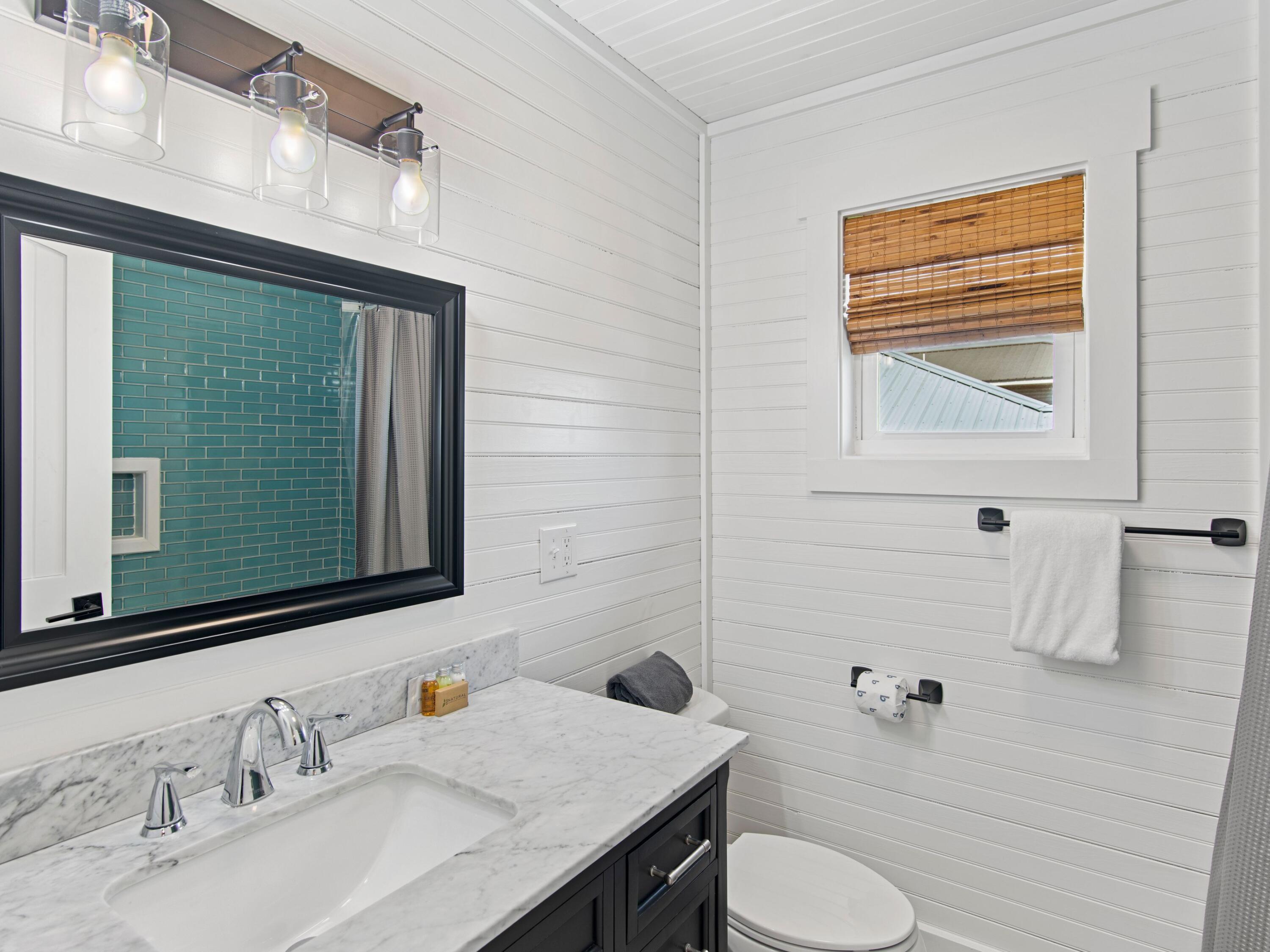 89 Tarpon Street Destin, FL 32541 - Photo 49 of 53 a bathroom with a granite countertop toilet sink and mirror
