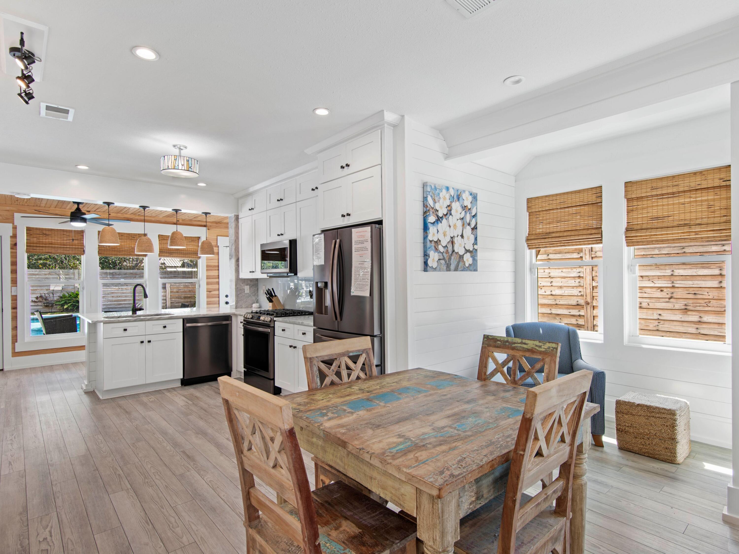 89 Tarpon Street Destin, FL 32541 - Photo 7 of 53 a kitchen with stainless steel appliances granite countertop a kitchen island hardwood floor sink stove dining table and chairs