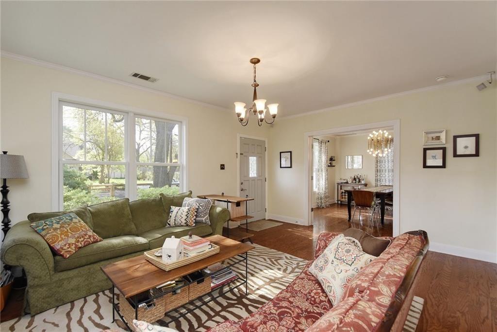 4412 Barrow Avenue, Unit A Austin, TX 78751 - Photo 2 of 28 Living room with dark wood-style flooring, crown molding, and a chandelier