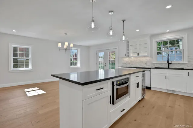 a kitchen with stainless steel appliances granite countertop a sink a stove a refrigerator and island