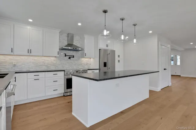 a kitchen with kitchen island a counter top space appliances and cabinets