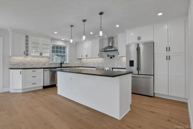 a kitchen with stainless steel appliances granite countertop a sink a refrigerator and a stove