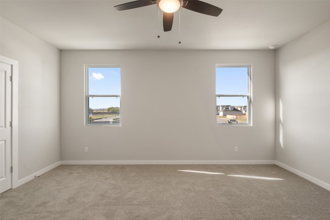 17408 Monastrell Lane Pflugerville, TX 78664 - Photo 19 of 31 an empty room with windows and chandelier fan