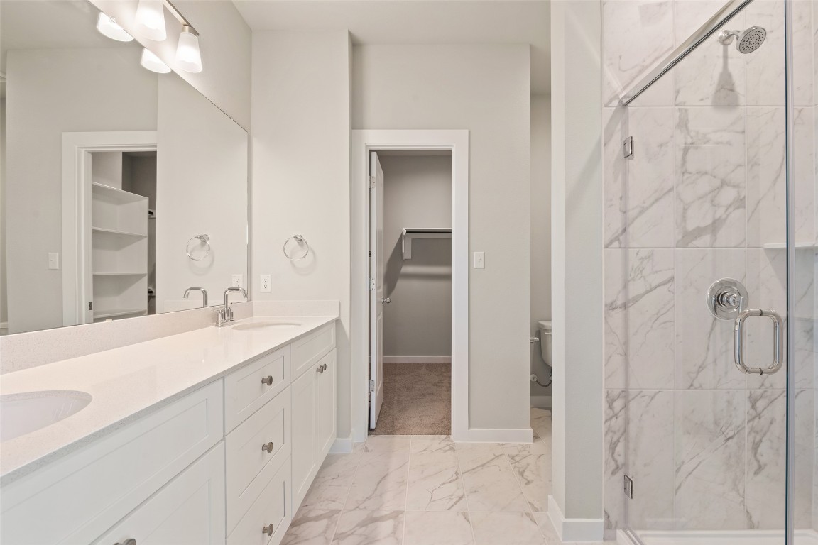17408 Monastrell Lane Pflugerville, TX 78664 - Photo 21 of 31 a spacious bathroom with a double vanity sink a mirror and a shower