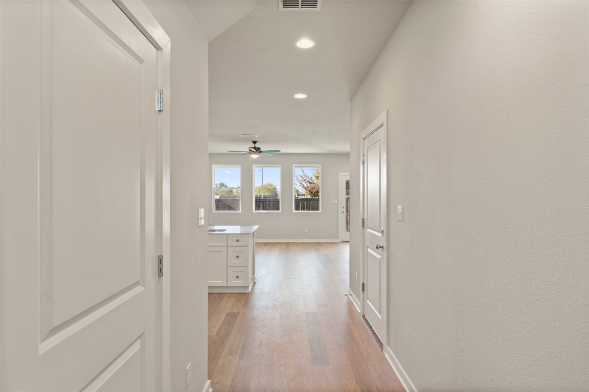 17408 Monastrell Lane Pflugerville, TX 78664 - Photo 3 of 31 a view of a hallway with wooden floor and a bathroom