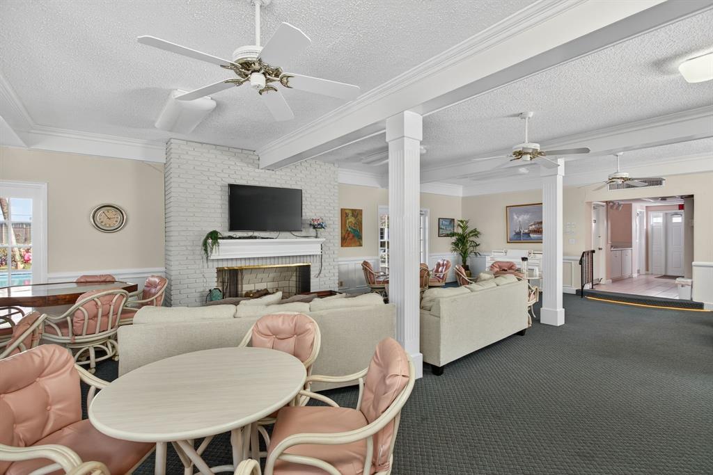 418 South Cypress Road, Unit 110 Pompano Beach, FL 33060 - Photo 25 of 27 a living room with furniture a fireplace and a flat screen tv