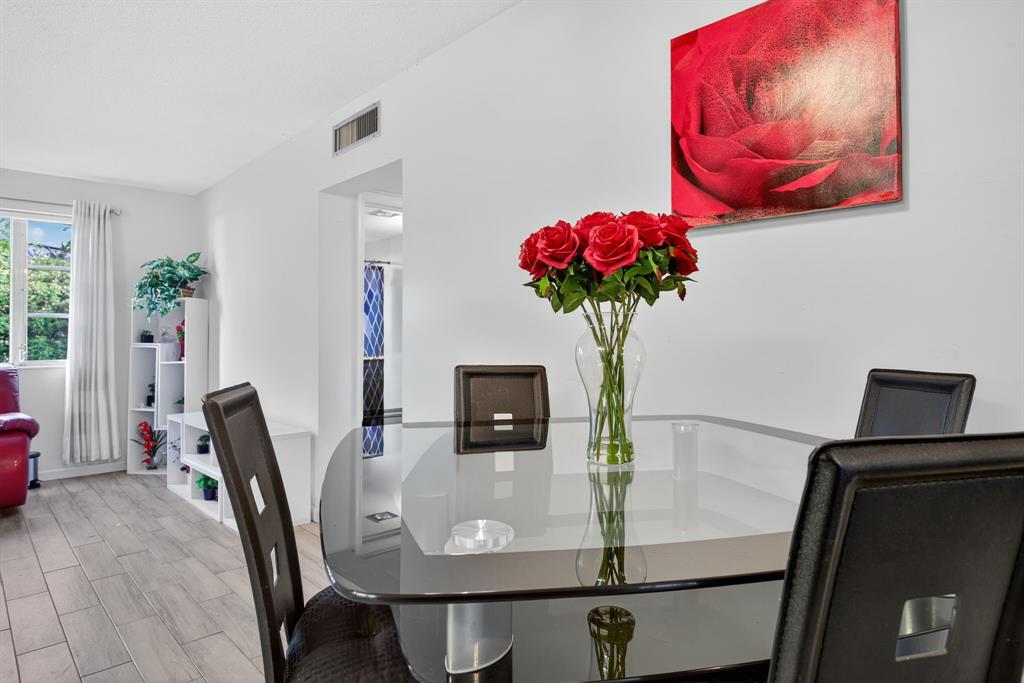 418 South Cypress Road, Unit 110 Pompano Beach, FL 33060 - Photo 8 of 27 a view of a dining room with furniture and flowers