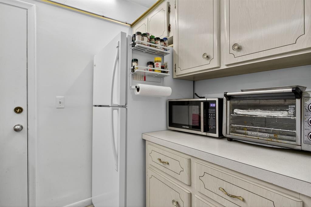418 South Cypress Road, Unit 110 Pompano Beach, FL 33060 - Photo 10 of 27 a kitchen with white cabinets and stainless steel appliances