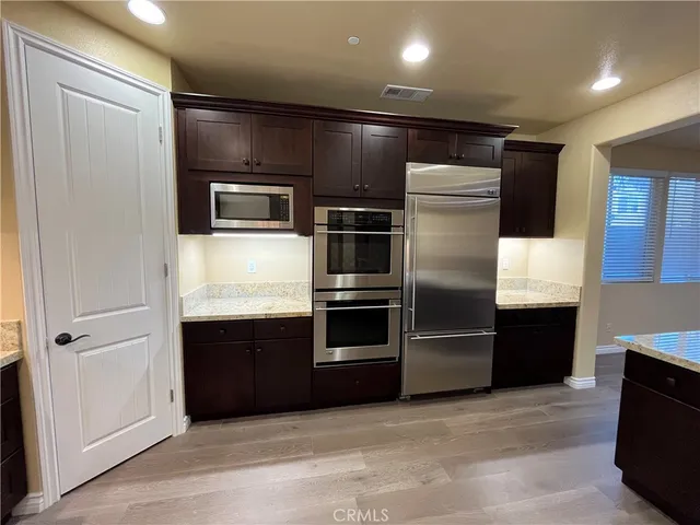 a modern kitchen with stainless steel appliances and refrigerator