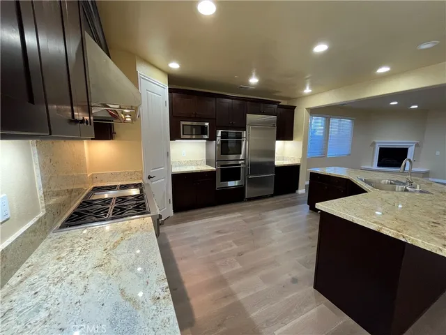 a kitchen with stainless steel appliances granite countertop a sink stove and refrigerator