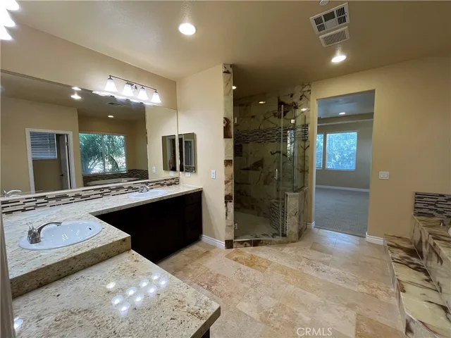 a large bathroom with a sink a large mirror and a shower