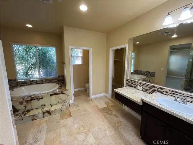a bathroom with a sink mirror and a bathtub