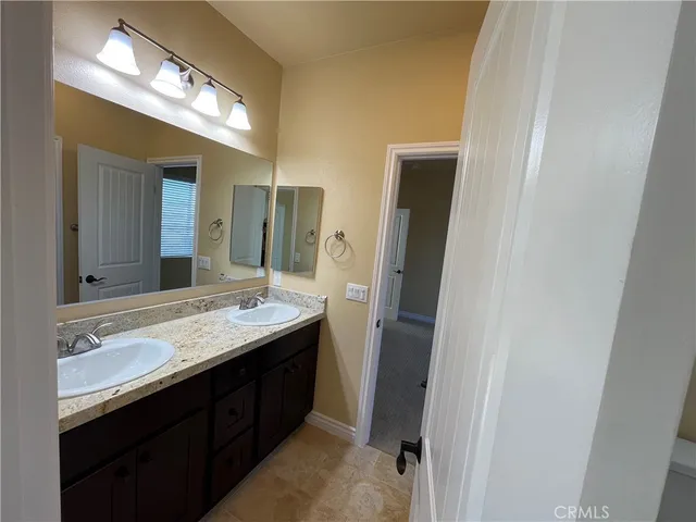 a bathroom with a double vanity sink and a mirror