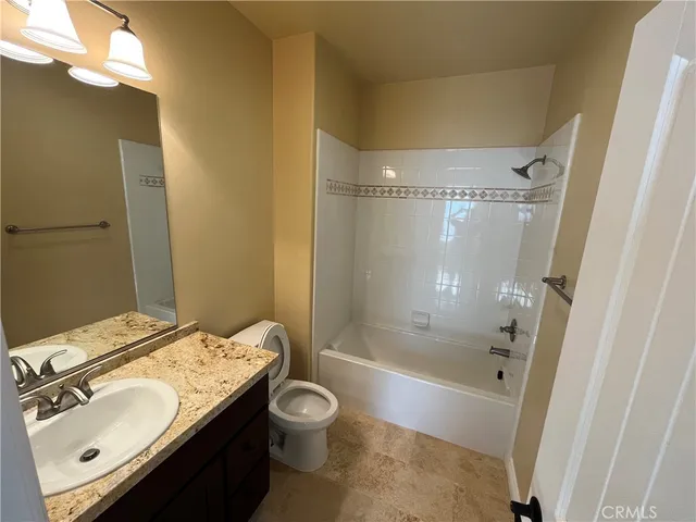 a bathroom with a sink mirror vanity and toilet