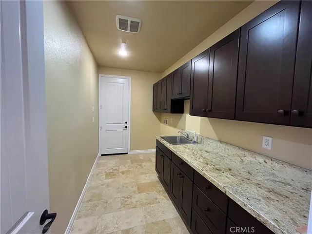 a large kitchen with granite countertop counter top space cabinetry and a wooden floor