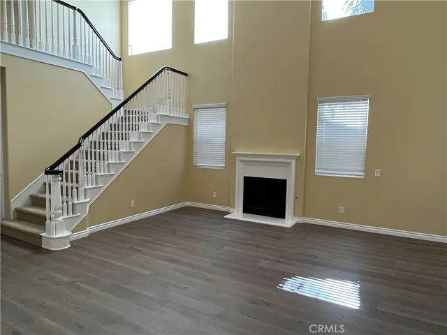 a view of a livingroom with wooden floor and a staircase