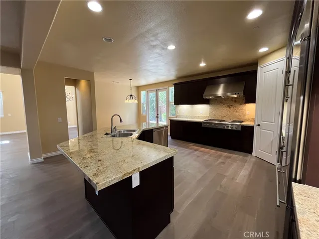 a kitchen with granite countertop sink and refrigerator