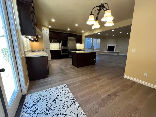 a kitchen with stainless steel appliances kitchen island granite countertop a refrigerator and a stove top oven