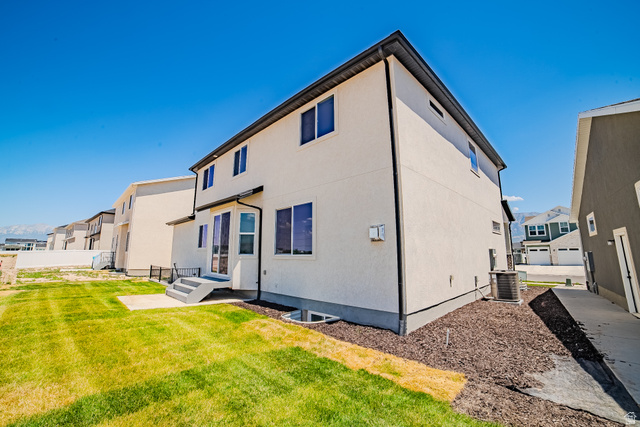 45 North Scarlet Maple Road, Unit 4317 Vineyard, UT 84059 - Photo 4 of 35 Rear exterior featuring a two-story design, stucco siding, multiple windows, a ground-level patio, and a grass lawn