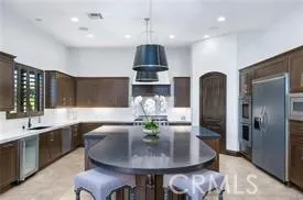 a kitchen with stainless steel appliances granite countertop a dining table and chairs