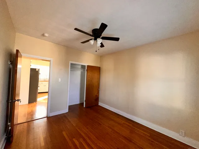 a view of a livingroom with wooden floor and a ceiling fan