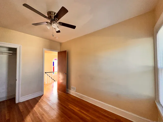 a view of a big room with wooden floor and windows in a room