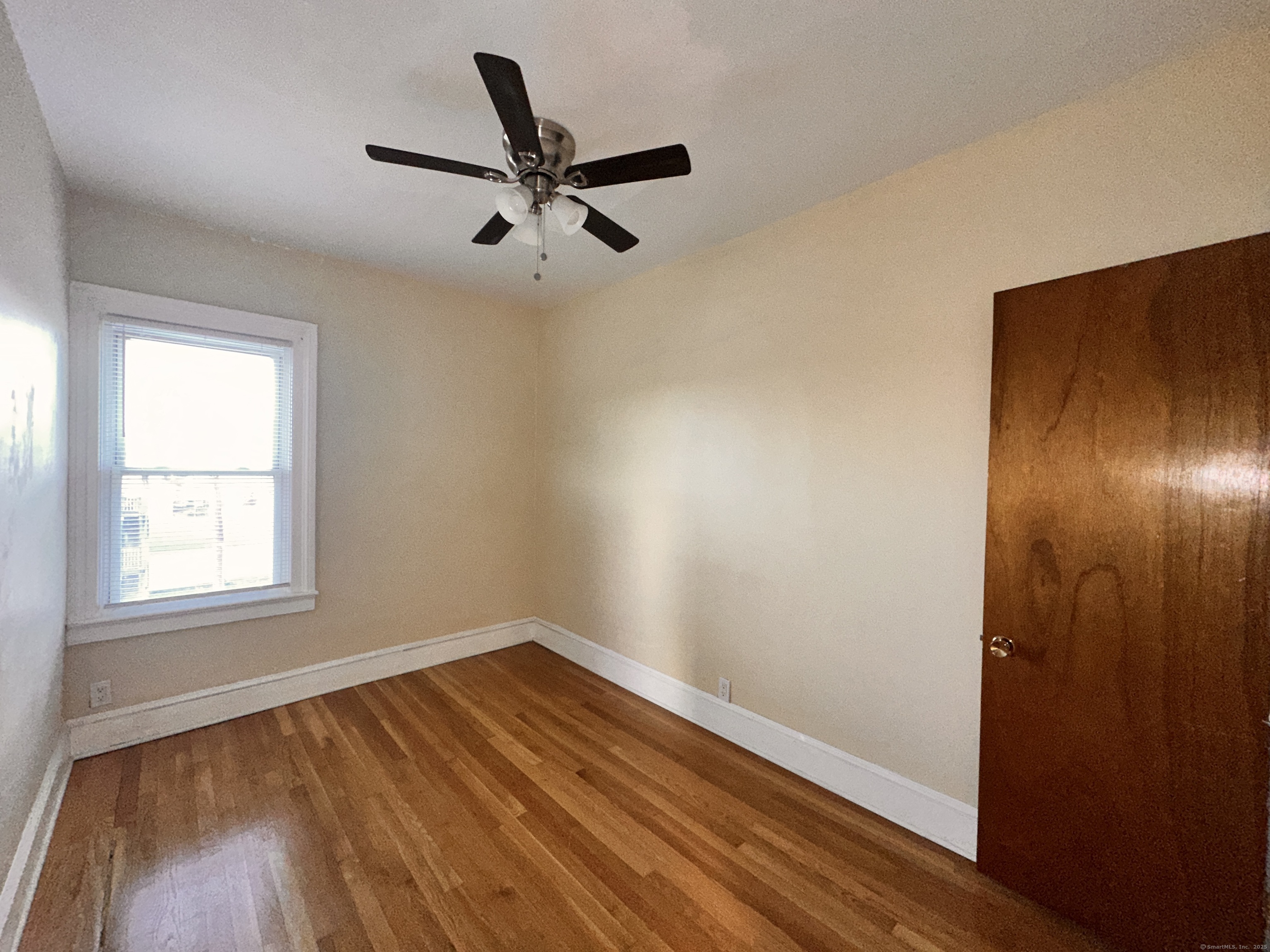 34 North Spring Street Ansonia, CT 06401 - Photo 14 of 20 a view of empty room with wooden floor and fan