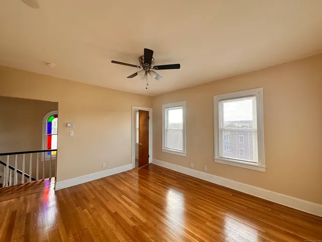 a view of a livingroom with wooden floor and a ceiling fan