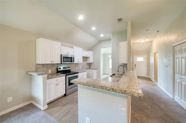 a kitchen with stainless steel appliances granite countertop a sink stove and refrigerator