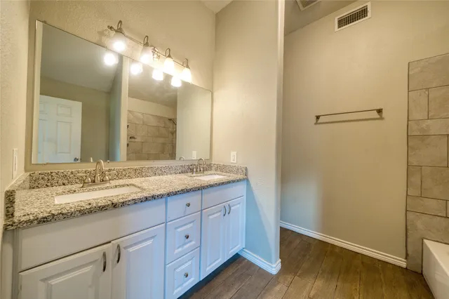 a bathroom with a granite countertop sink and a mirror