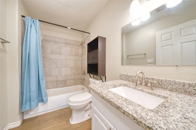 a bathroom with a granite countertop sink toilet and shower