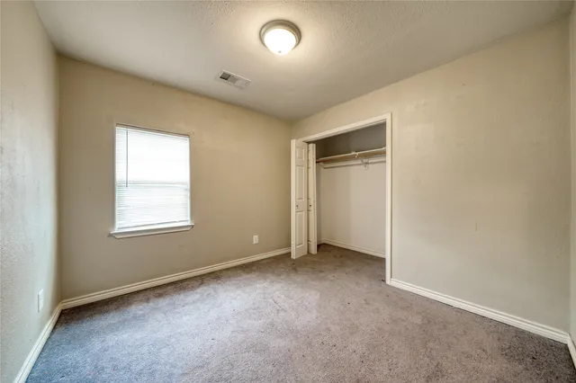 an empty room with a chair and a window
