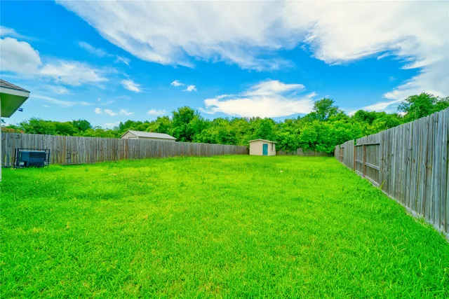 a view of yard with swimming pool and green space