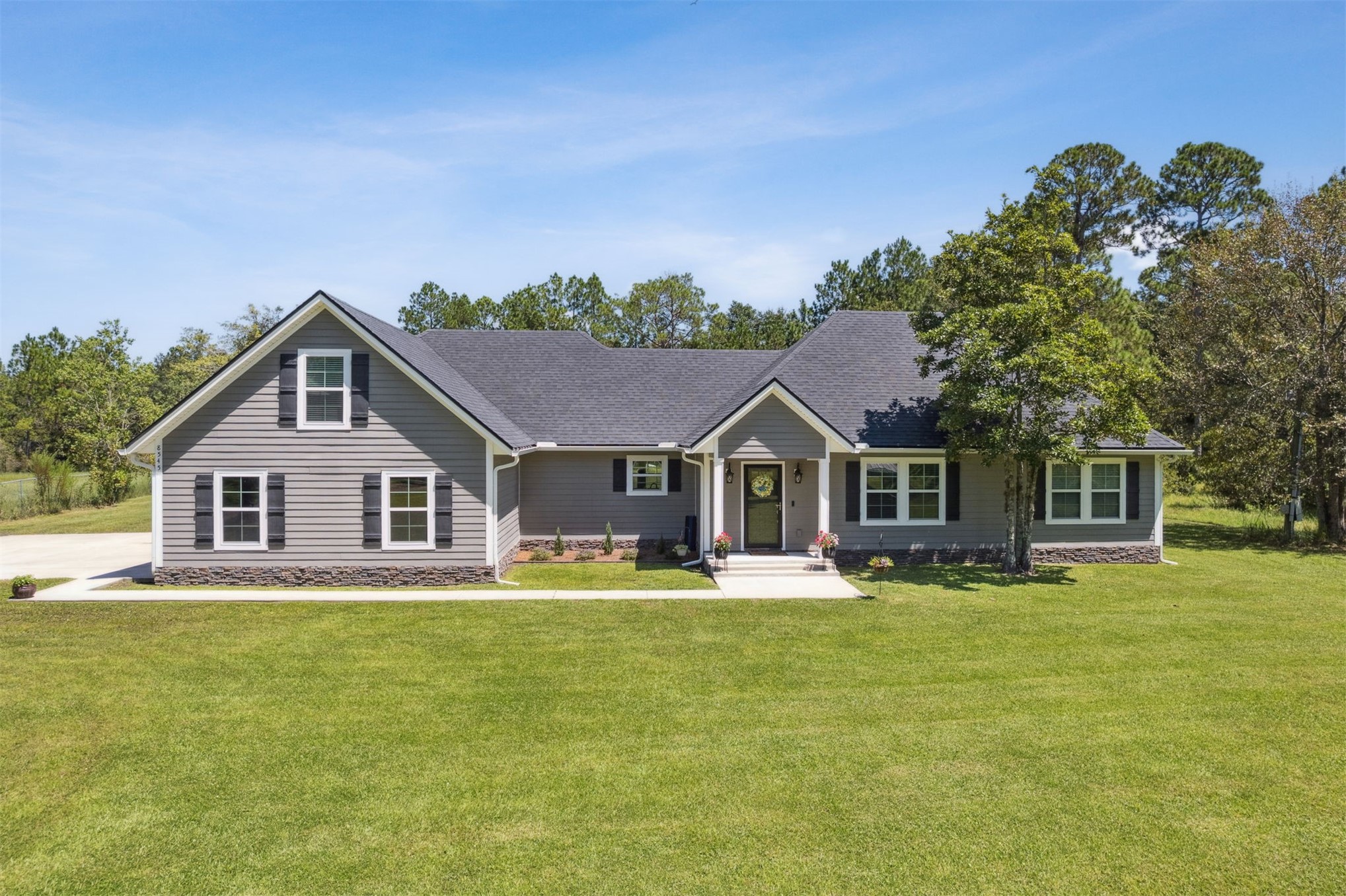 a front view of house with yard and trees in the background