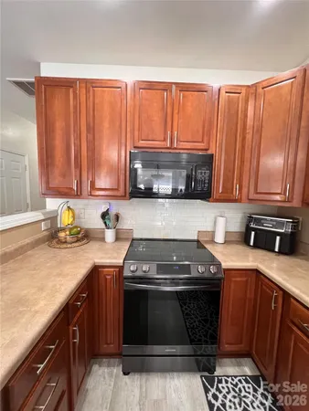 a kitchen with stainless steel appliances granite countertop a refrigerator a stove a sink and a microwave
