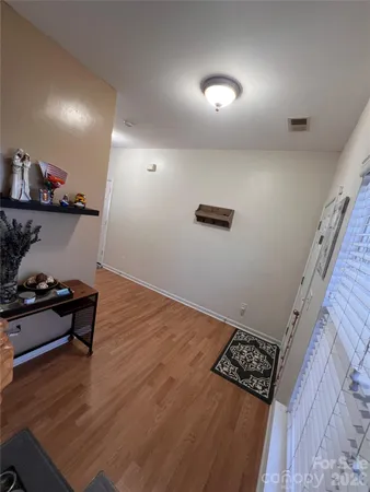 an empty room with wooden floor and a fireplace