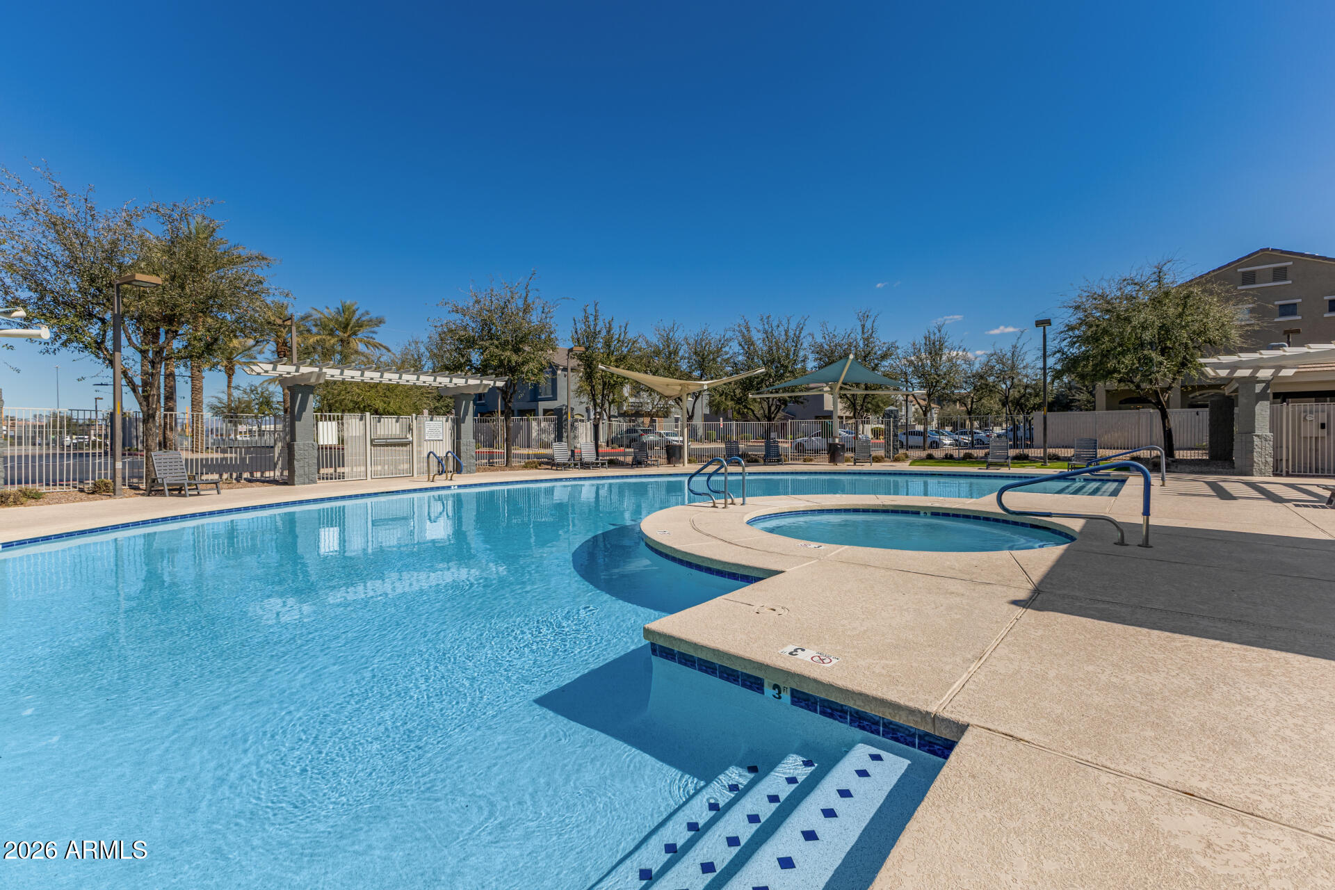 2402 East 5th Street, Unit 1590 Tempe, AZ 85288 - Photo 27 of 33 a view of a swimming pool with a lawn chairs and palm tree