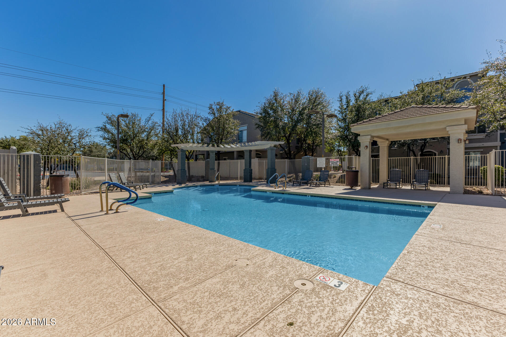 2402 East 5th Street, Unit 1590 Tempe, AZ 85288 - Photo 30 of 33 a view of a swimming pool with a bench and lawn chairs