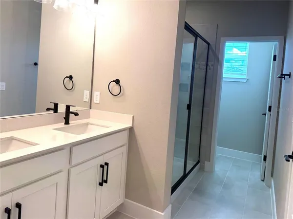 a bathroom with a double vanity sink and a mirror