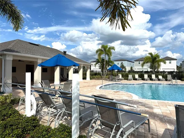 a view of a house with swimming pool and sitting area
