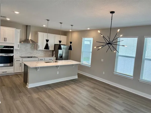 a kitchen with kitchen island a counter top space appliances and a ceiling fan