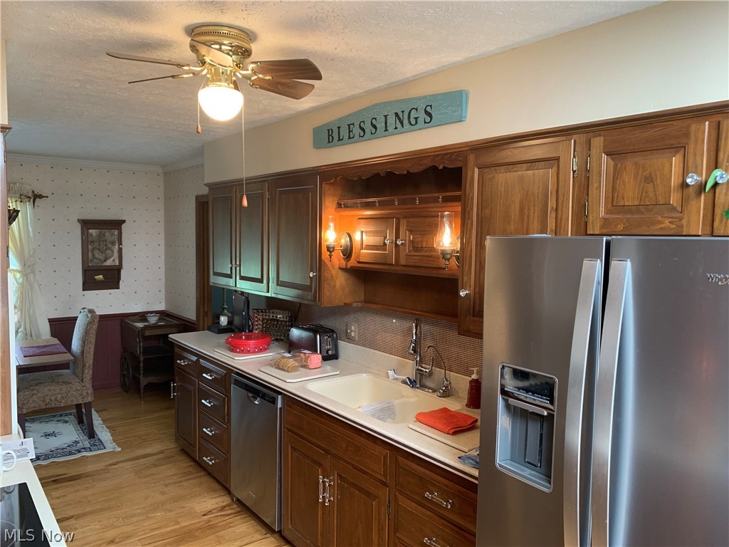 303 Orchard View Road Northeast Lancaster, OH 43130 - Photo 23 of 50 Kitchen featuring light wood-type flooring, appliances with stainless steel finishes, sink, ceiling fan, and a textured ceiling