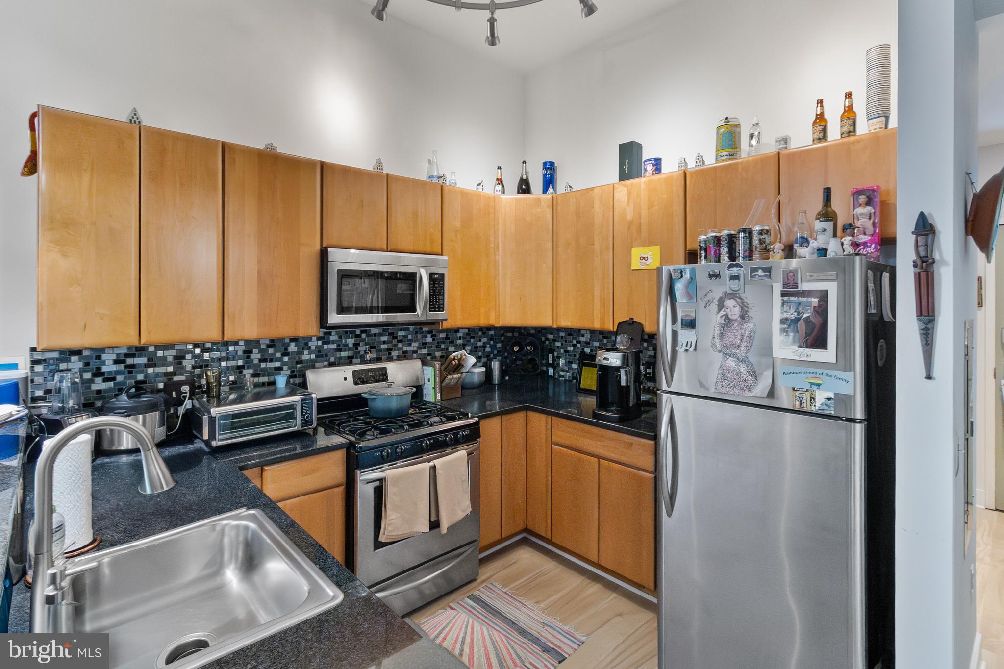 22 South Howard Street, Unit R503 Baltimore, MD 21201 - Photo 9 of 29 a kitchen with stainless steel appliances a sink a stove a refrigerator a counter top space and cabinets
