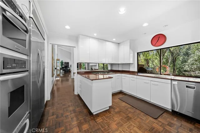 a kitchen with stainless steel appliances granite countertop a refrigerator and a sink