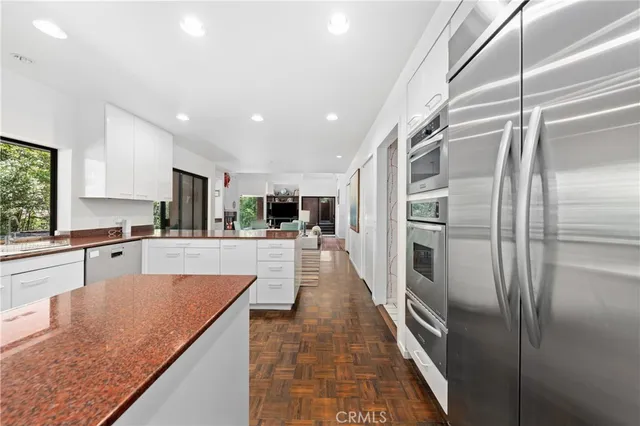 a large kitchen with stainless steel appliances granite countertop a sink and cabinets