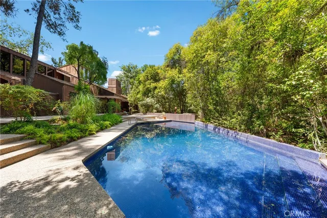 a view of house with swimming pool outdoor seating