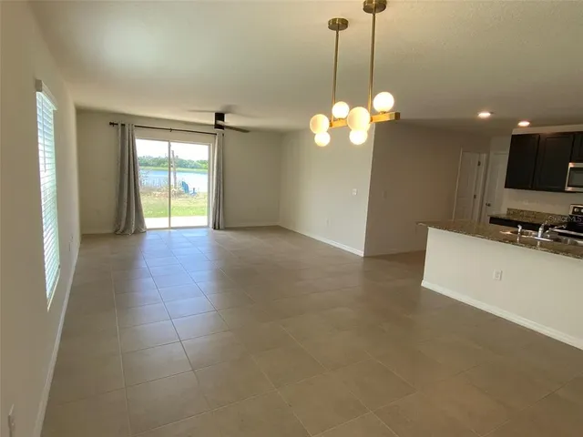 a view of an empty room with a kitchen