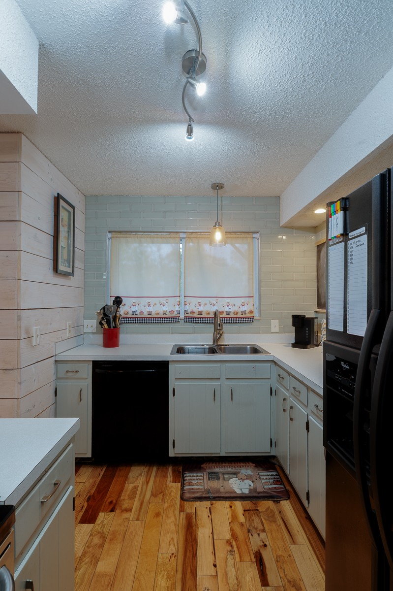 4000 Anderson Road, Unit 82 Nashville, TN 37217 - Photo 12 of 30 a kitchen with a sink dishwasher a stove and white cabinets with wooden floor