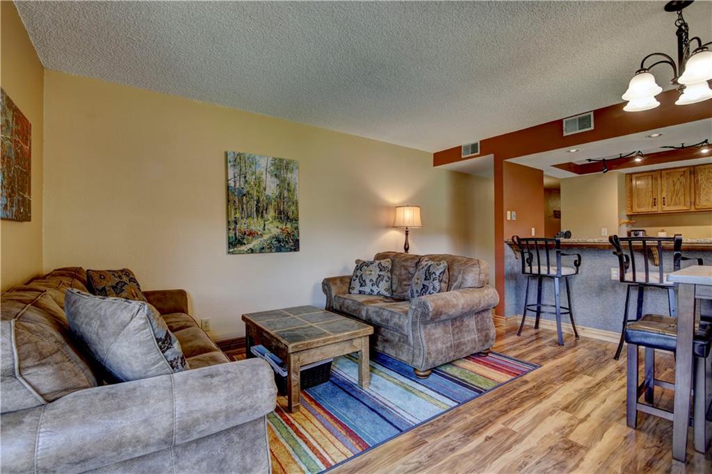 520 Bills Ranch Road, Unit 173 Frisco, CO 80443 - Photo 3 of 24 a living room with furniture and a dining table with wooden floor